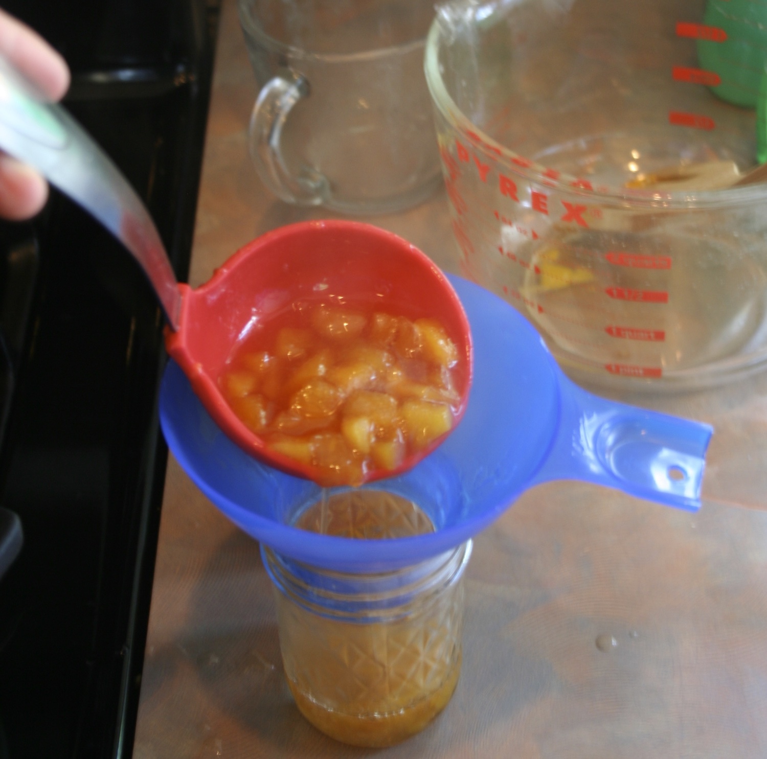 pouring jam into a canning jar