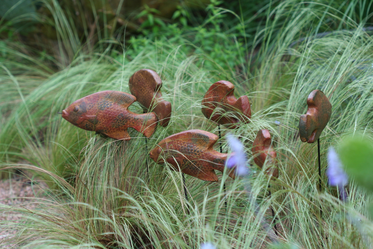 wooden fish swimming through grass